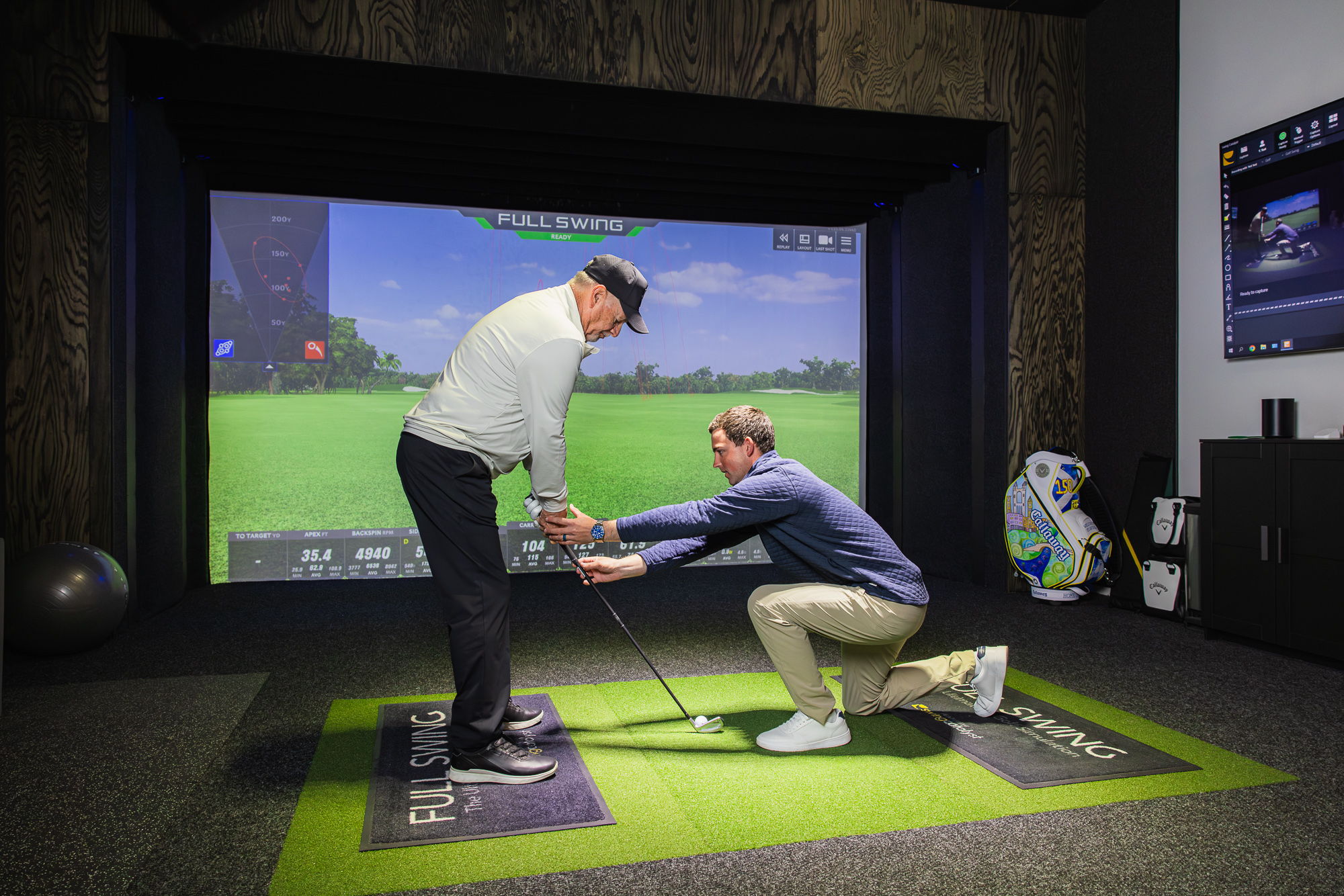 Instructor working with a golfer at the simulator